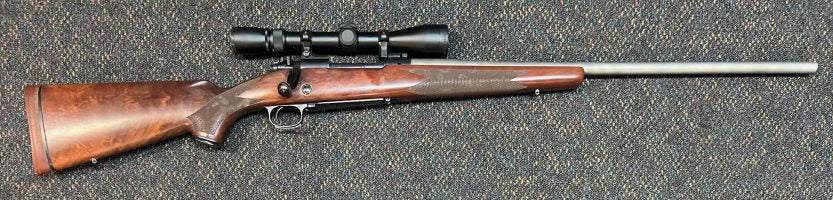 Winchester Model 70 Super Grade in 338 Win Mag. Controlled round feed. Has been re-barreled with Stainless 25" PSECO barrel. Comes with Weaver 2-10x38 scope in 