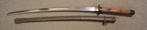 Sidelock with metal scabbard. Cross hatched wooden handle in original "Oak" finish almost mint. Bright, clean blade retaining original factory edge finish with 