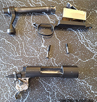 Remington 700 action with DAMAGED feed rails. Left side feed rail is broken off and has been smoothed. Right side present but has some damage. Bolt and trigger 