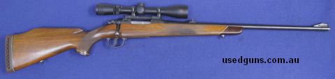 Timber stock, blue barrel, internal magazine with hinged floor plate, open sights still still on barrel.