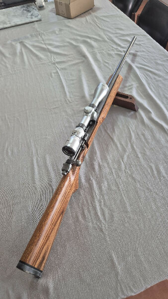 All metal parts Cerakoted in light grey. 2 stage trigger. Semi varmint barrel. Laminated timber stock.